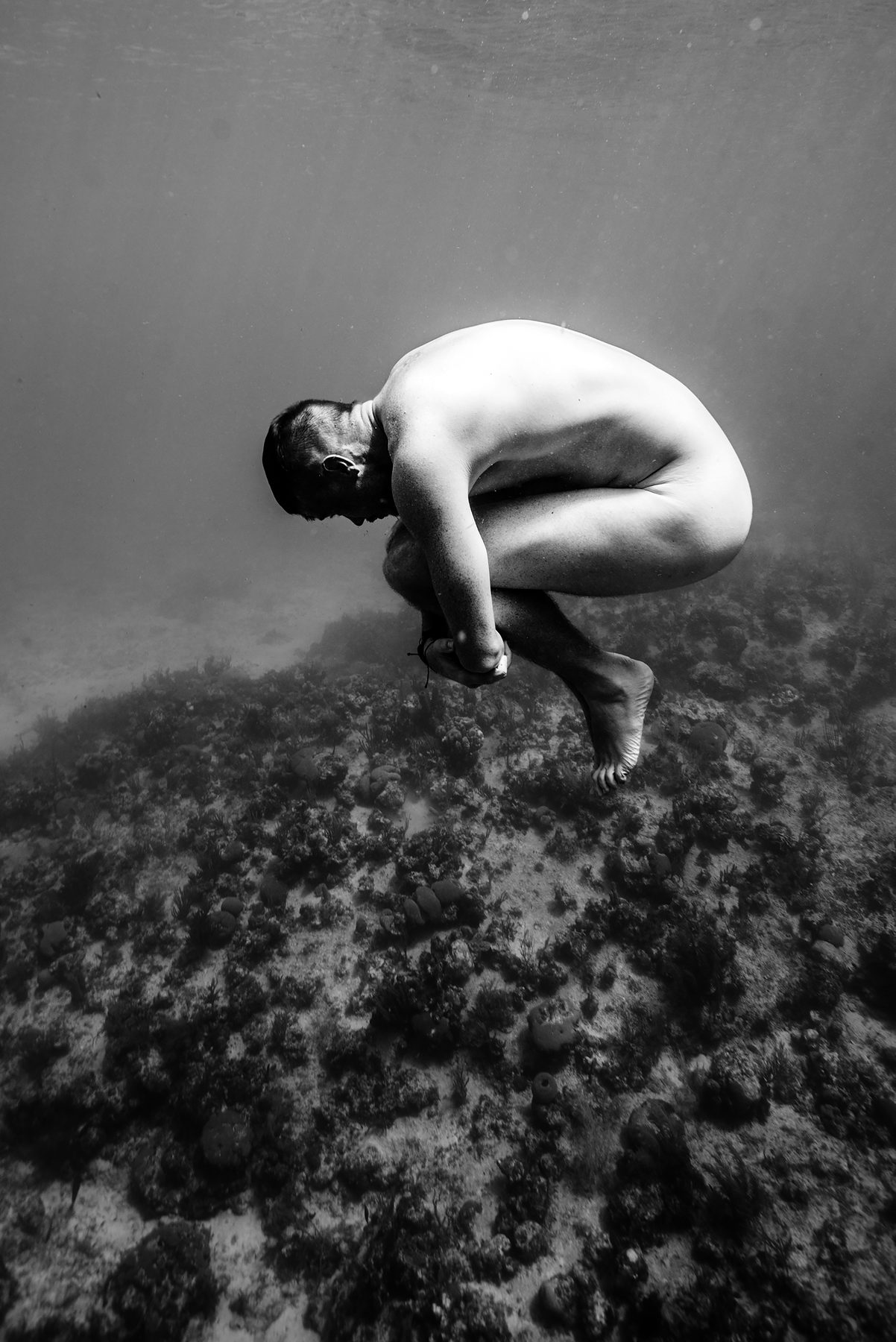 Un cuerpo acurrucado sobre el fondo, en blanco y negro